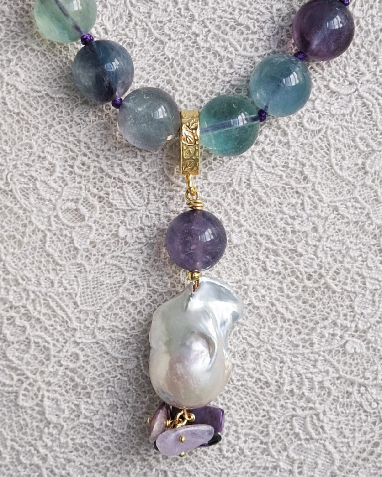Collana Girocollo in Fluorite Collana Girocollo in Fluorite, Chips di Sugilite e Perla Barocca